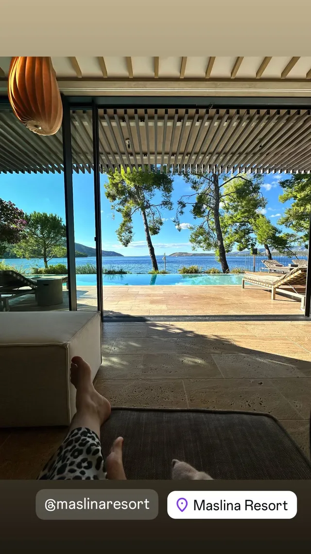 Hayley Atwell reclining beside an open view of the sea.