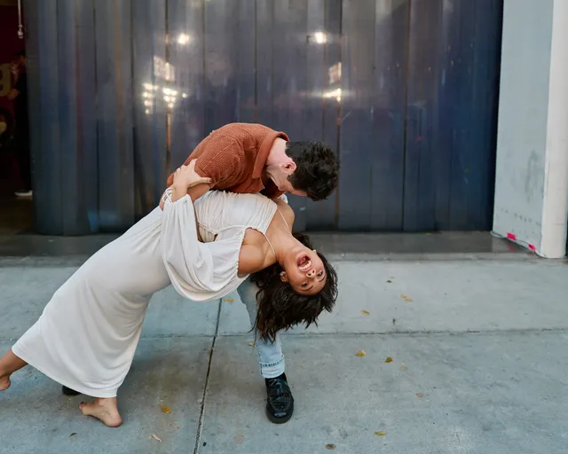 Xochitl Gomez leaning backward barefoot during an outdoor dance pose.