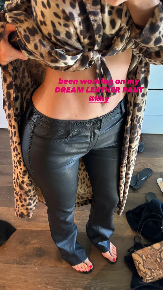 Kylie Jenner taking a mirror selfie in jeans while barefoot.