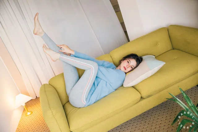 Han So-hee reclining barefoot on a yellow sofa.