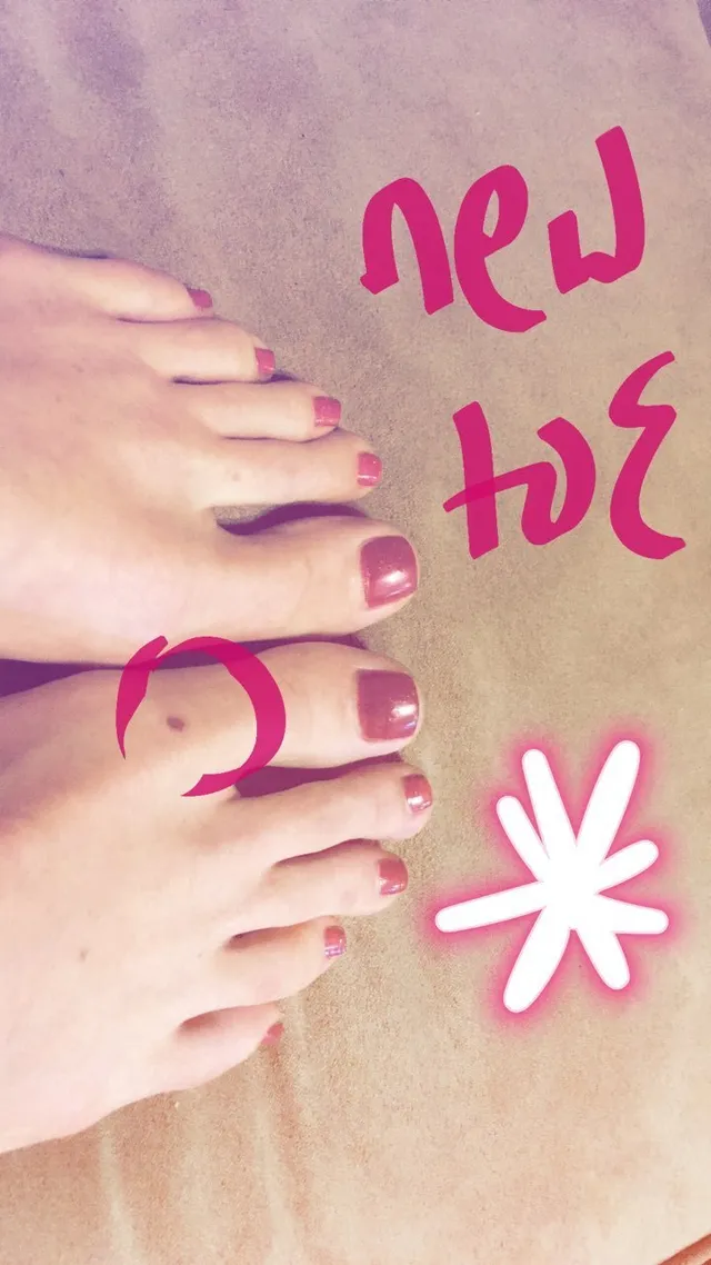 Alice Eve showing pink toenail polish in a relaxed snapshot.