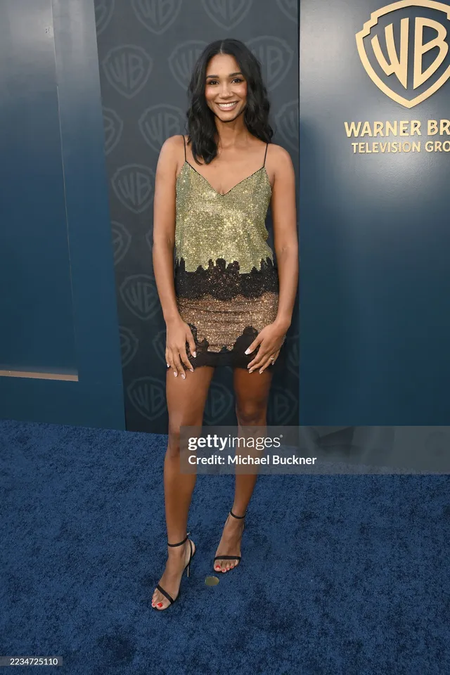 Greta Onieogou posing in a lace mini dress and black heels at an event.