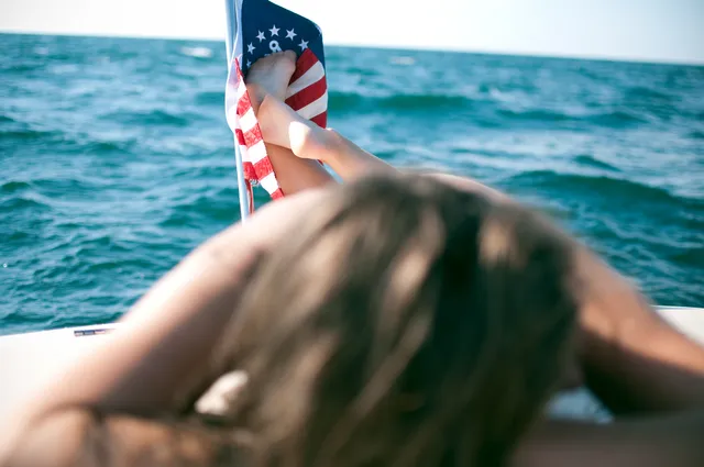 Melissa Benoist raising a bare foot beside the sea in a screen scene.