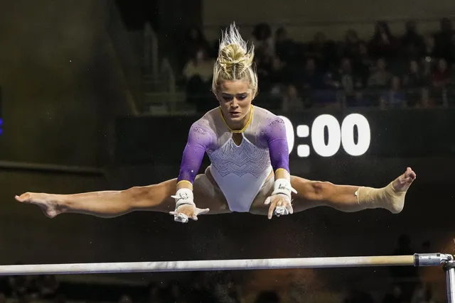 Olivia Dunne: performing a barefoot straddle leap on a balance beam.