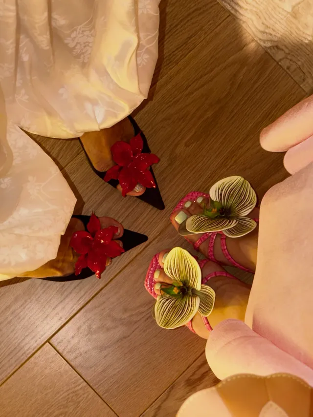 Lisa (Lalisa Manobal) showing black pointed heels decorated with red flowers.