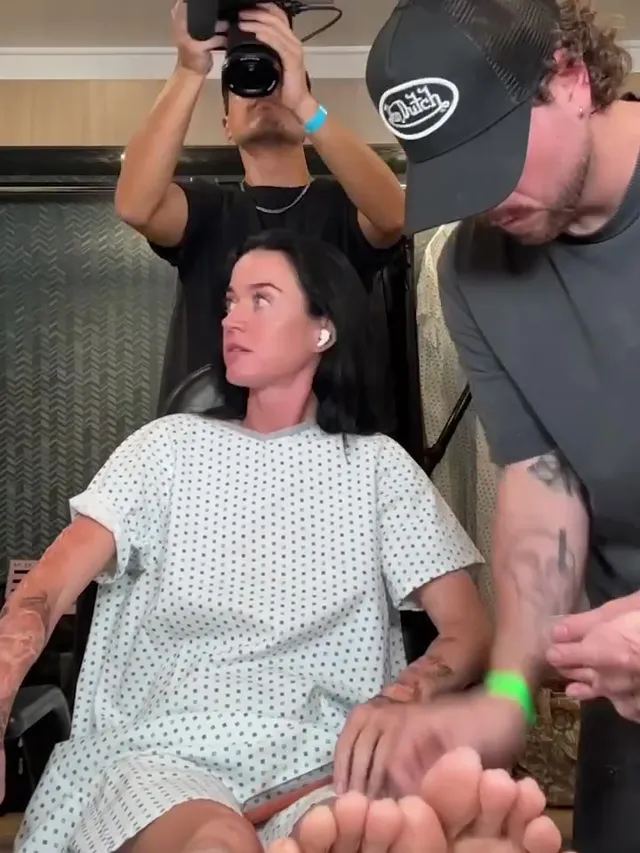 Katy Perry showing bare soles while sitting in a makeup chair.
