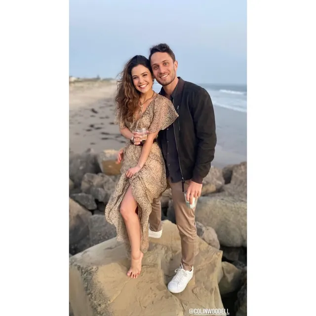 Danielle Campbell standing with a companion on coastal rocks.