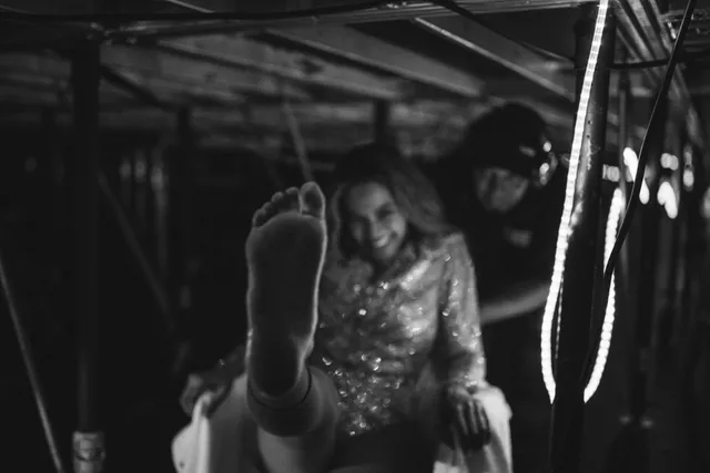 Beyoncé raising a bare sole toward the camera in a monochrome portrait.