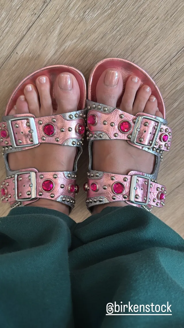 Heidi Klum wearing pink studded flat sandals with buckles.