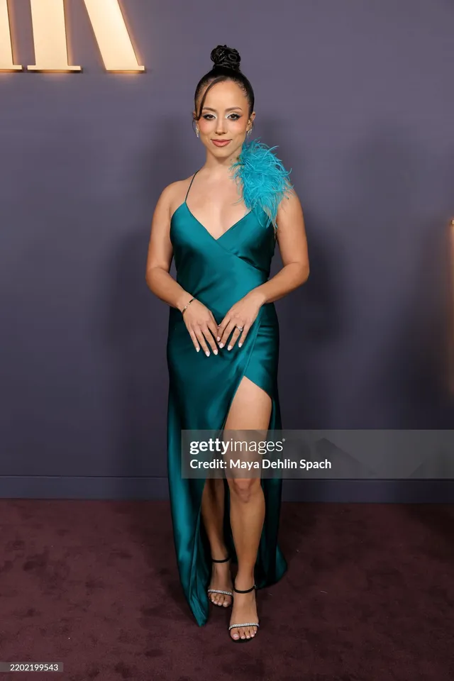 Kiana Madeira wearing a teal dress and ankle-strap heels at an event.