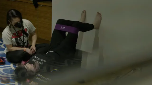 Billie Eilish relaxing indoors with her bare feet raised.