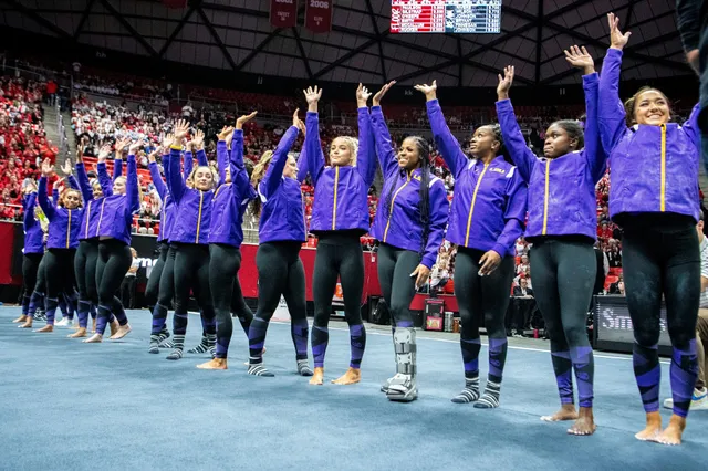 Olivia Dunne standing with a gymnastics team in a competition arena.
