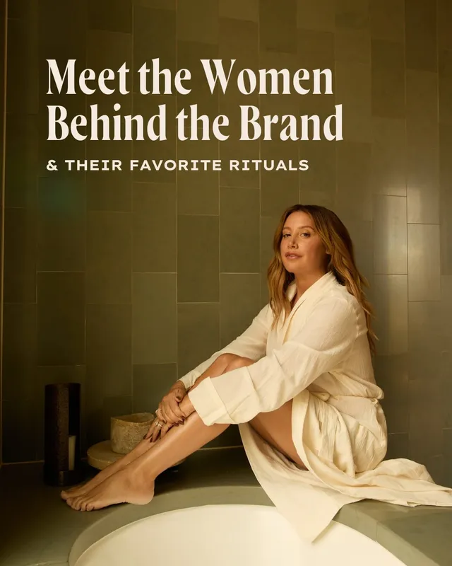 Ashley Tisdale sitting barefoot beside a bath in a pale robe during a wellness campaign.