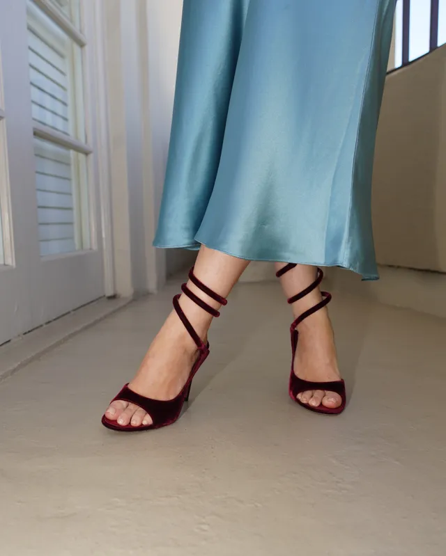 Joey King wearing burgundy heeled sandals beneath blue trousers.