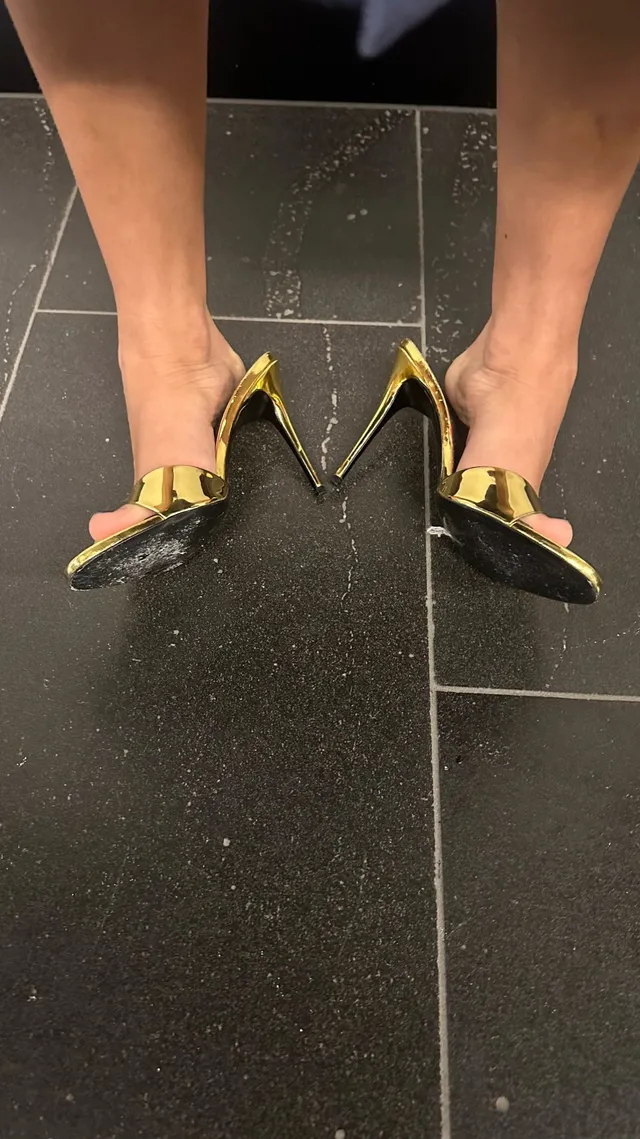 Ella Purnell wearing pointed gold slingback pumps.