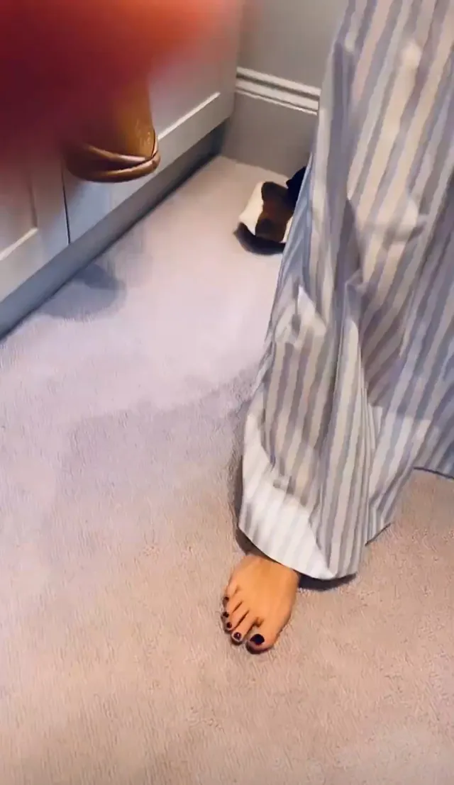 Olivia Wilde showing a bare foot beneath striped trousers.