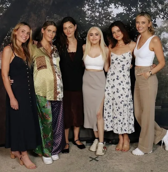 Danielle Campbell posing with companions in a floral dress.