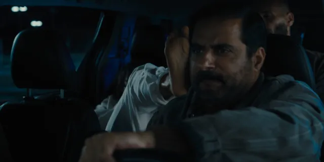 Zoe Saldaña appearing beside a man in a dramatic screen scene.
