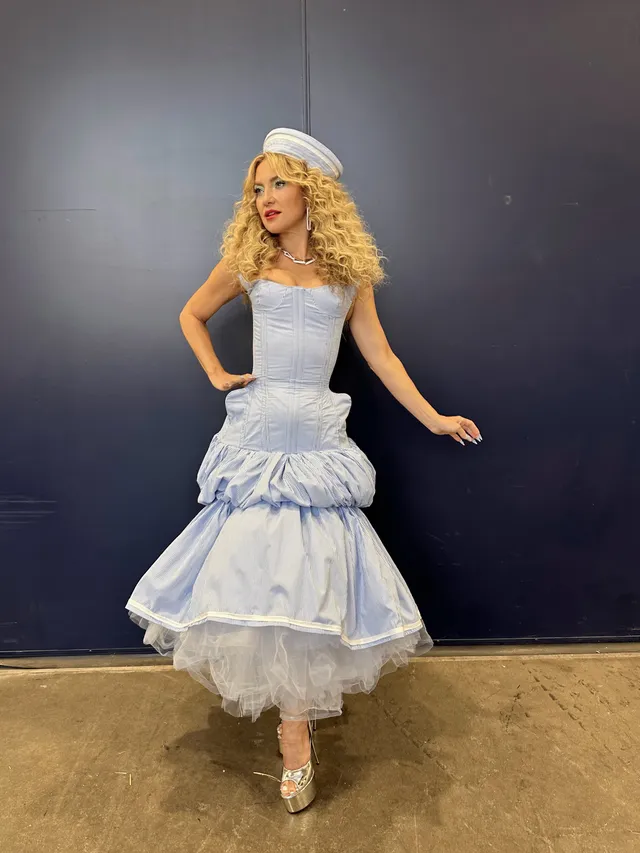 Kate Hudson posing in a tiered pale blue gown.