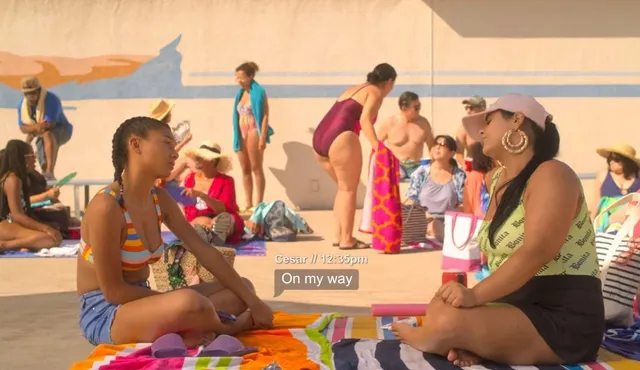 Sierra Capri sitting cross-legged beside a friend on a pool deck.