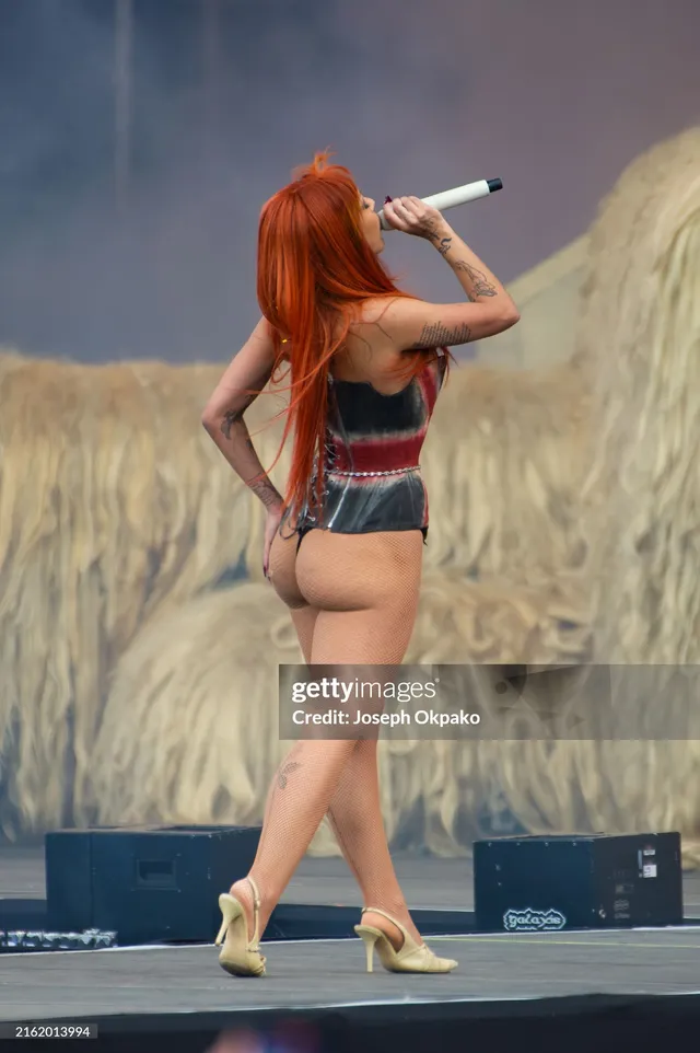 Doja Cat performing on a stage in gold heels.