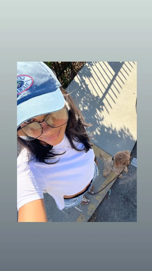 Greta Onieogou taking an outdoor selfie in jeans and flat sandals.