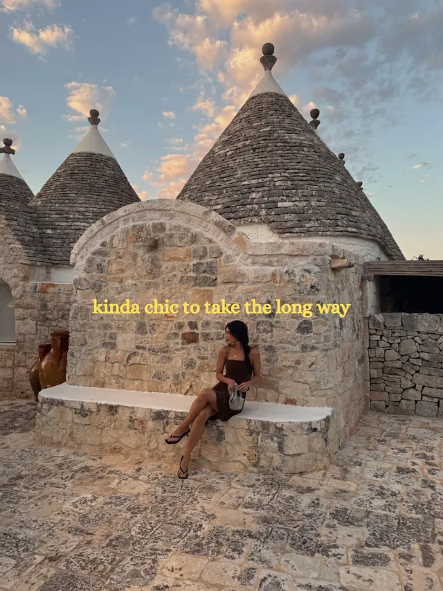 Danielle Campbell sitting beside stone buildings during a visit.