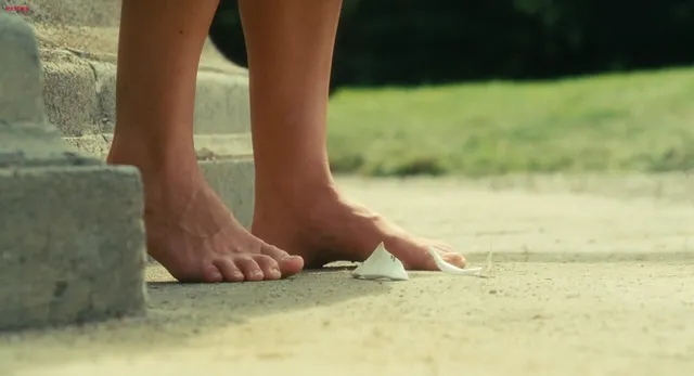 Keira Knightley a screen detail of bare feet on grass.