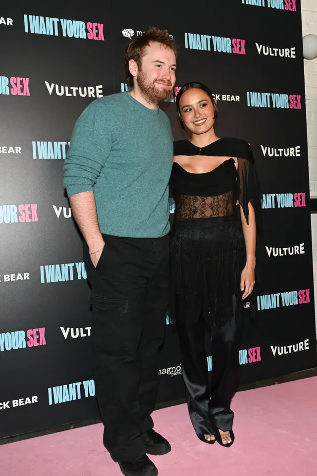 Chase Sui Wonders posing at a premiere with a guest in black heels.