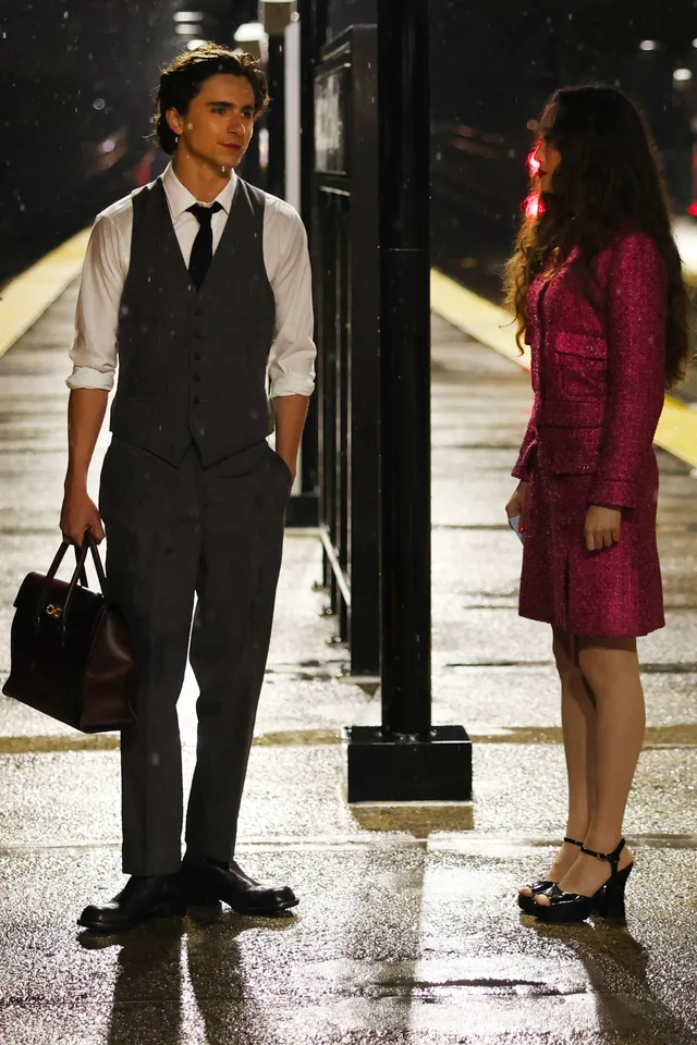 Havana Rose Liu standing on a train platform in black heels.