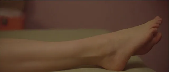 Léa Seydoux resting bare feet in a screen scene.