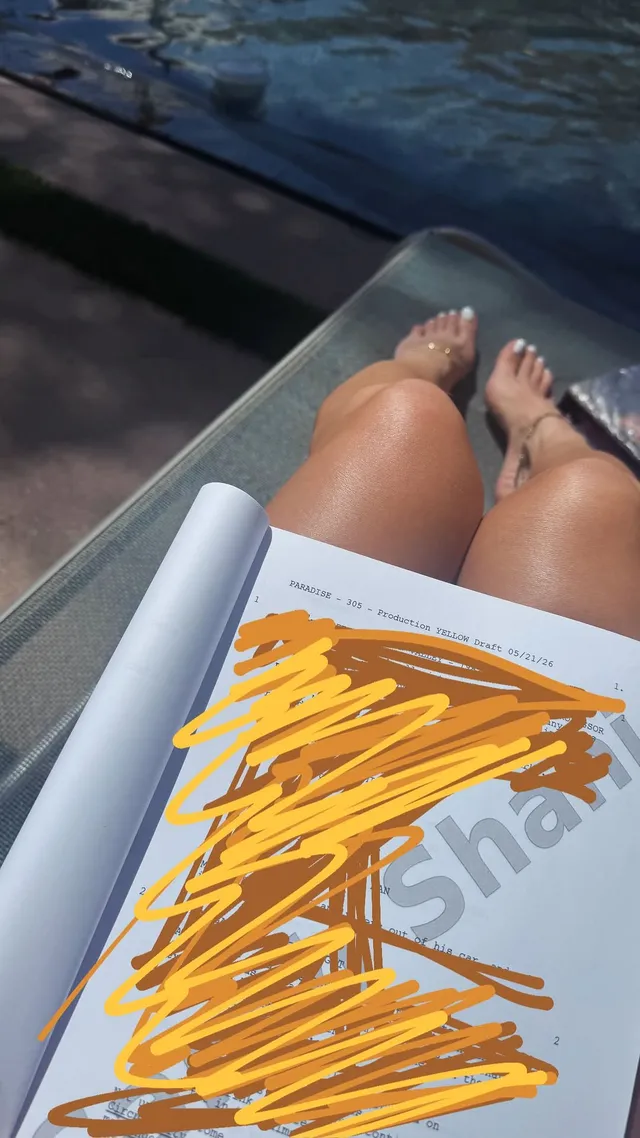 Sarah Shahi resting on a lounger beside water.