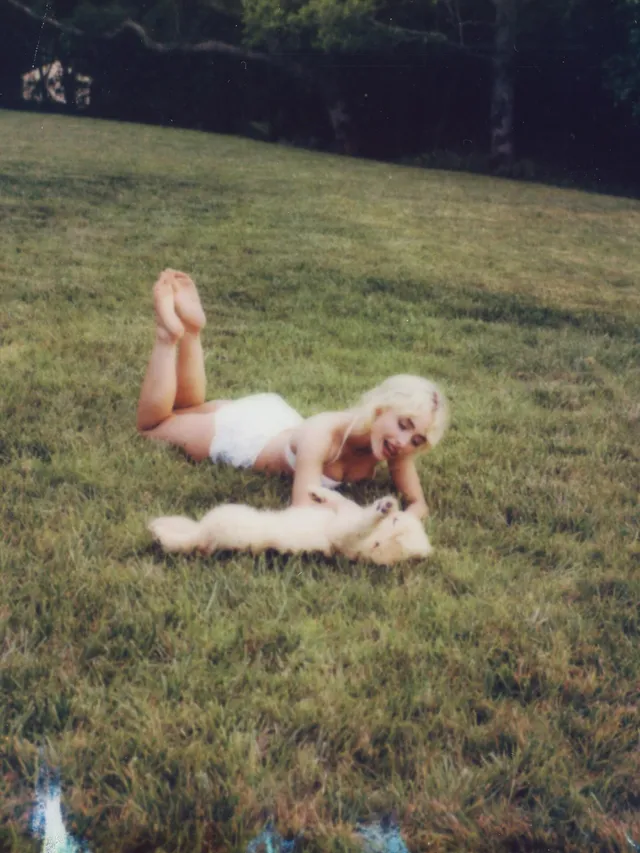 Sabrina Carpenter: lying barefoot on grass with her feet raised.