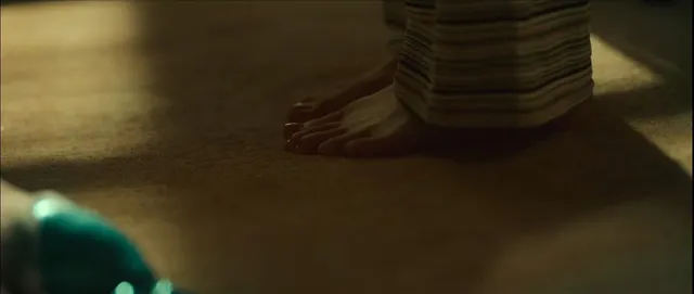 Bae Suzy standing barefoot in a dimly lit scene.