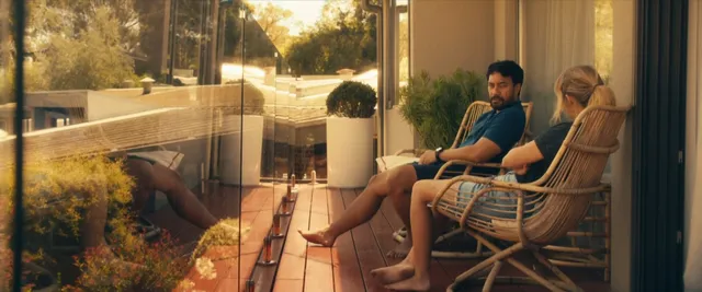 Teresa Palmer sitting with a companion on a porch during a screen scene.
