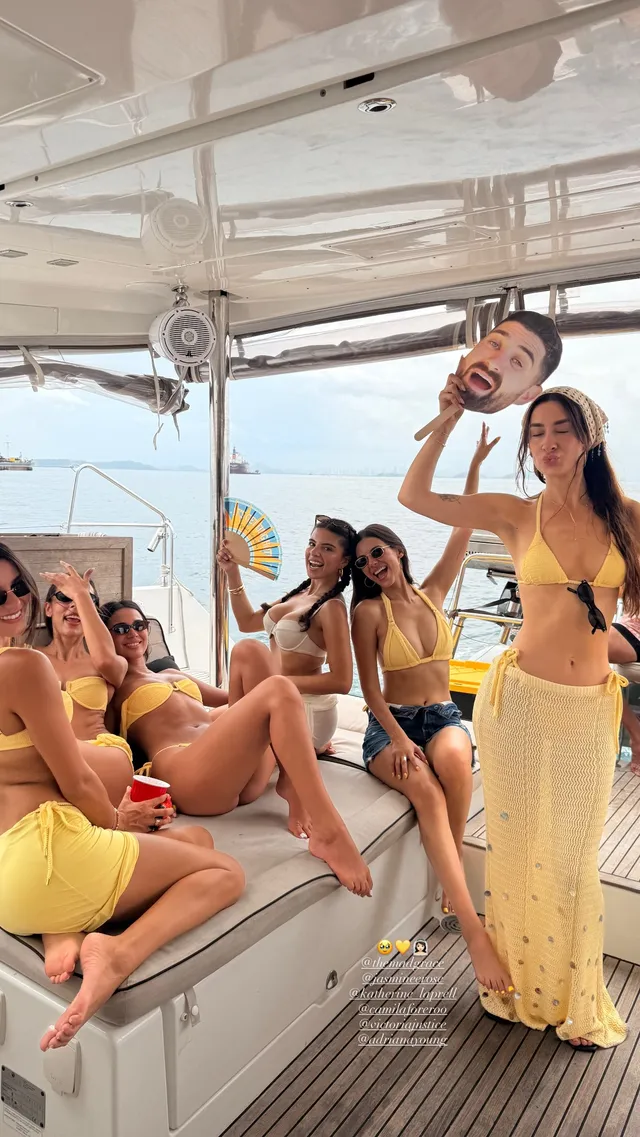 Victoria Justice standing barefoot with friends aboard a boat.