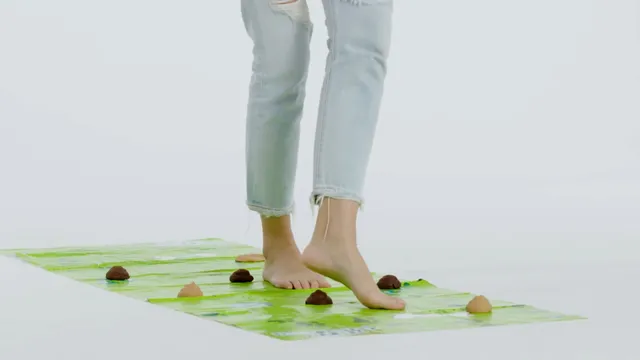 Gemma Chan standing on a green mat in a screen scene.