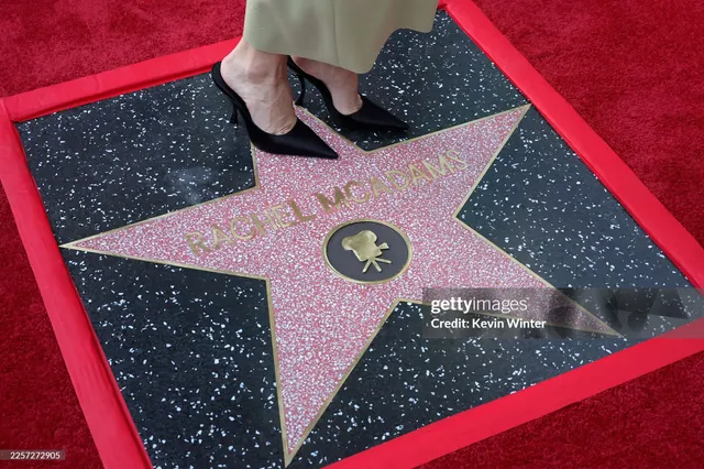 Rachel McAdams wearing black heels beside a pavement star.