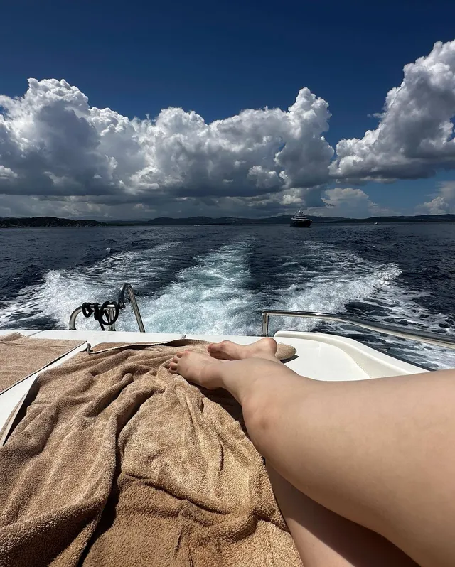 Alexandra Daddario a close view of her bare feet while relaxing on a boat.
