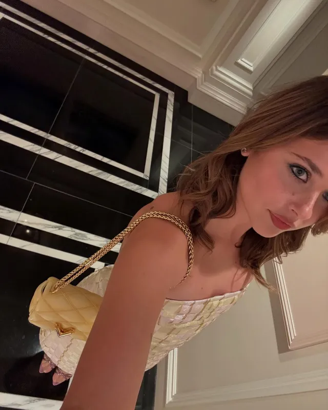 Nicole Wallace taking an indoor selfie in a pale embellished outfit.