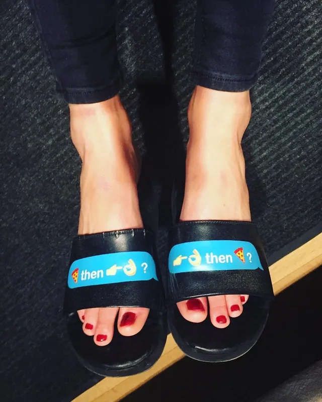 Samara Weaving wearing black slide sandals with painted toenails.