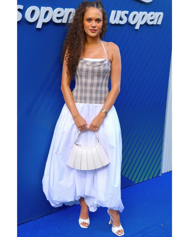 Madison Pettis wearing a pale blue dress and white heels at an event.