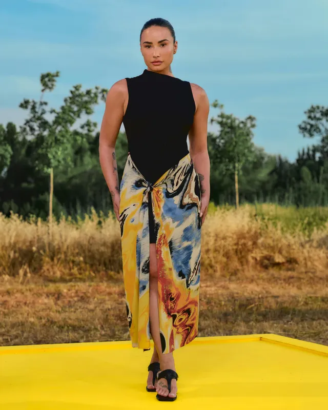 Demi Lovato posing in patterned trousers and black heels.