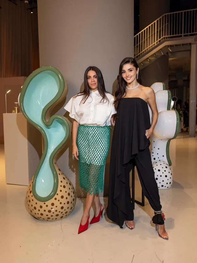 Hande Erçel standing with friends in a black outfit.