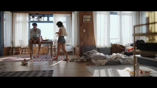 Emily Alyn Lind standing barefoot beside a man in a screen capture.