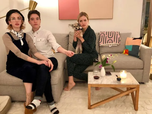 Willa Fitzgerald sitting barefoot on a sofa with companions.