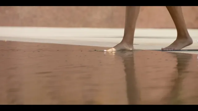 Samantha Logan shown with bare feet on a wooden floor.