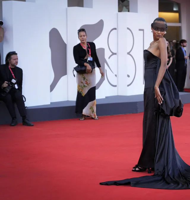 Sophie Wilde turning on a red carpet in a dark gown and heels.