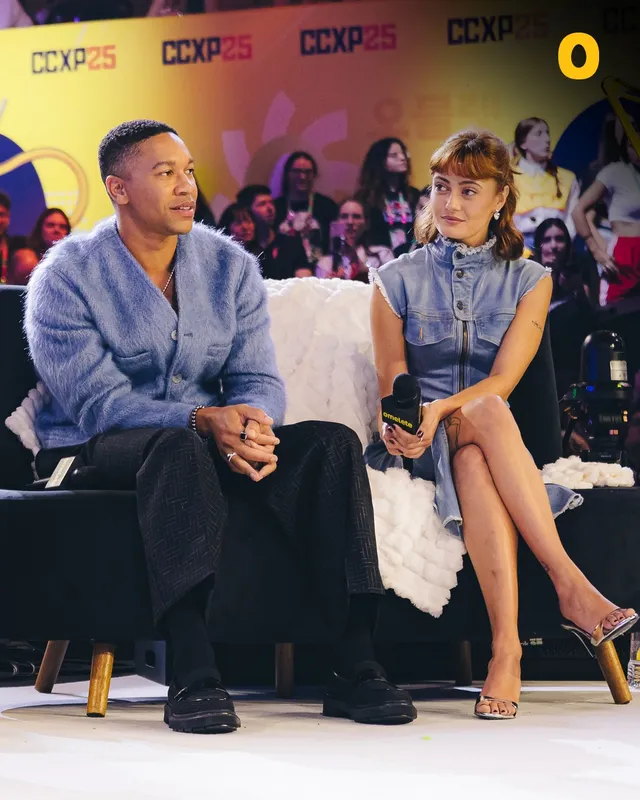 Ella Purnell sitting beside a guest during a convention interview.