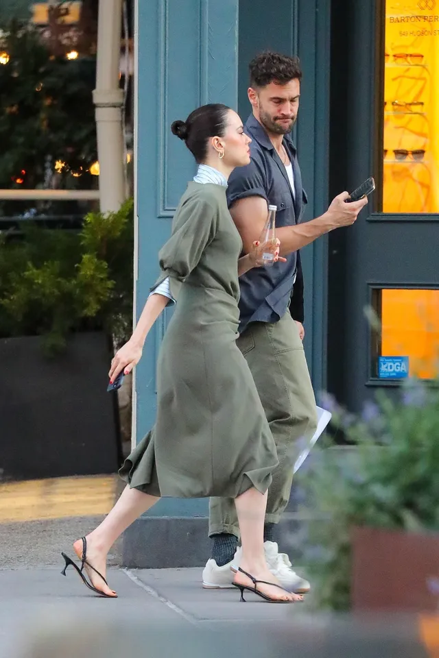 Daisy Ridley walking past a building with a companion.